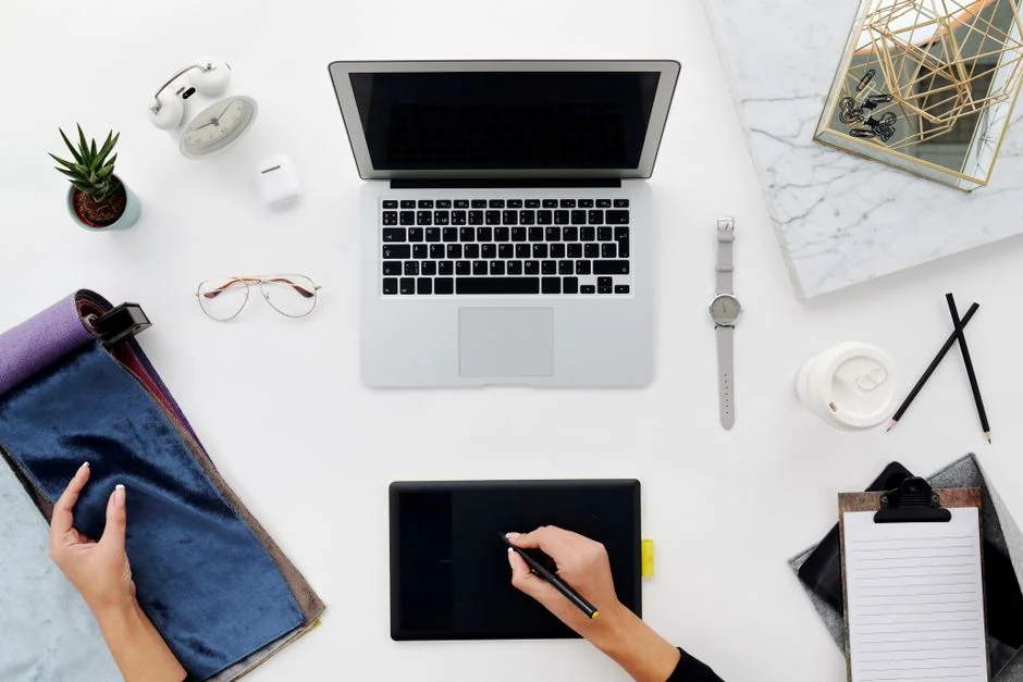 Build your dream website for your future. A laptop, MacBook, on top of a portable table with coffee tea mug on the side.